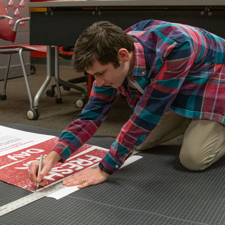 A student at the Multimedia Production Center working on a print.