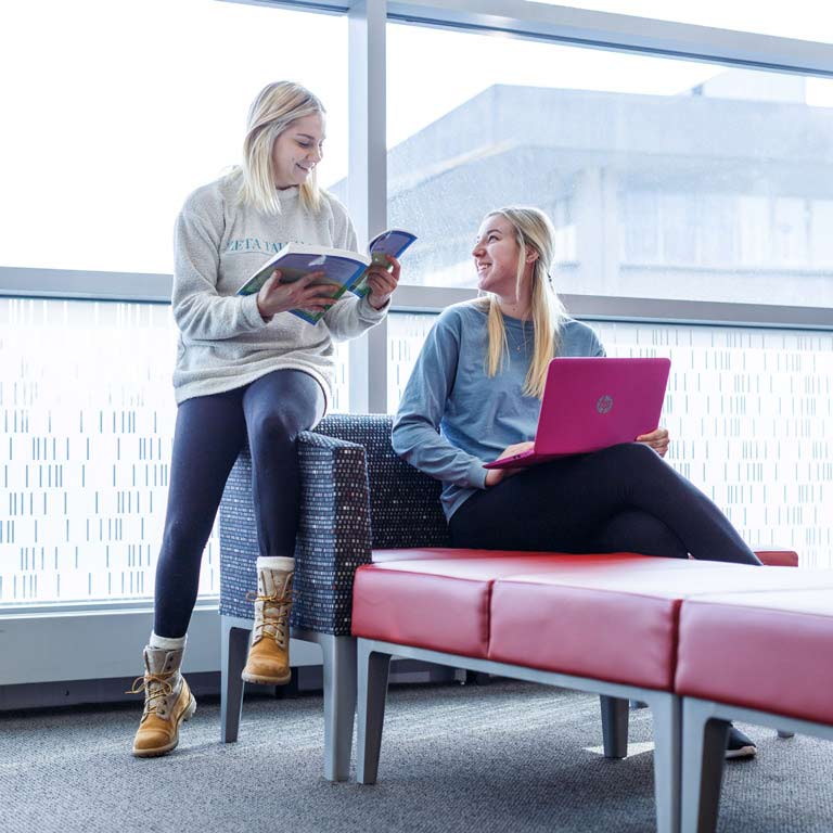 Two students speak in the cube.