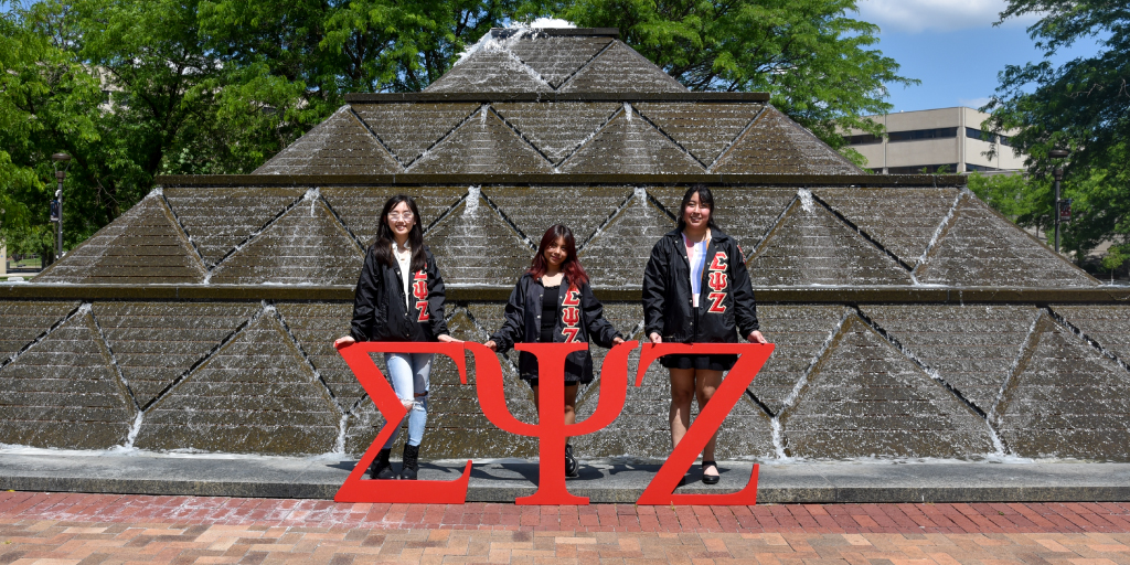 Members of the fraternity and sorority life community showing their greek letters by Wood Fountain.