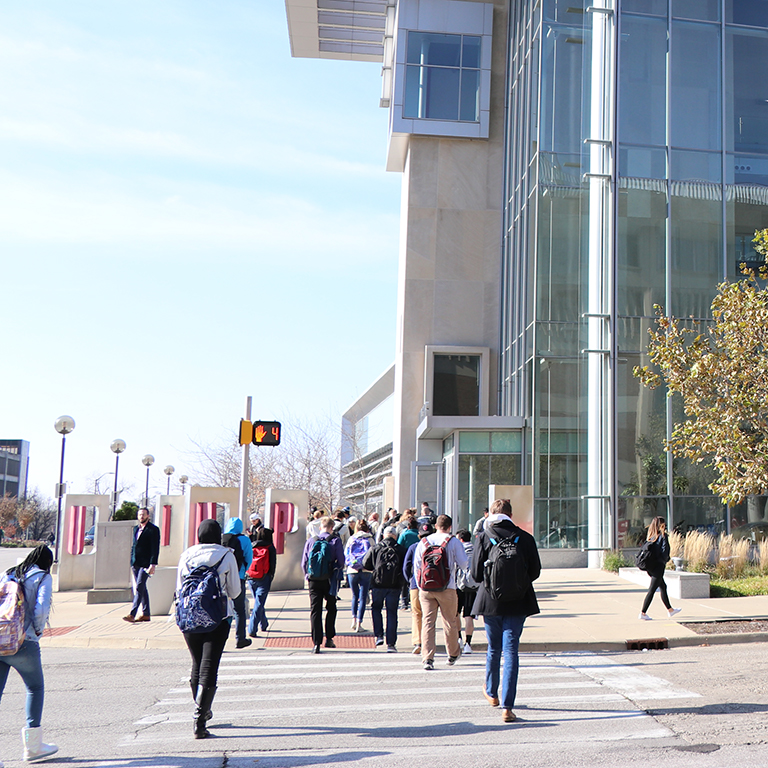 Students walk across university boulevard toward the Campus Center from Cavanaugh.
