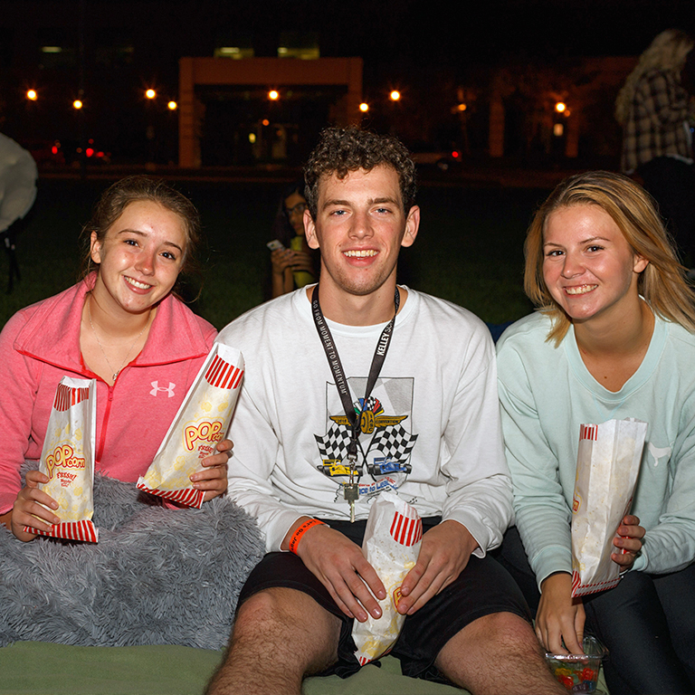 Students hold popcorn at movie night.