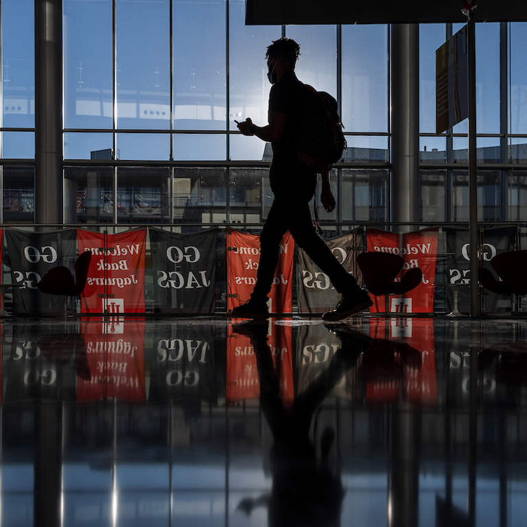 A silhouette of a person walking across the Campus Center.