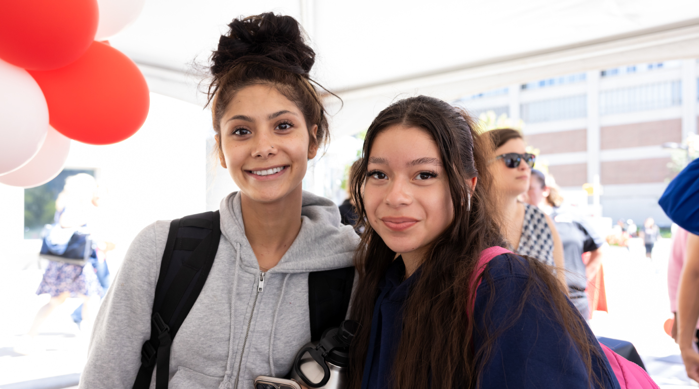 Two friends pose for a photo.